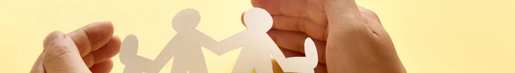 hands curved around paper cut out people in circle (resized)