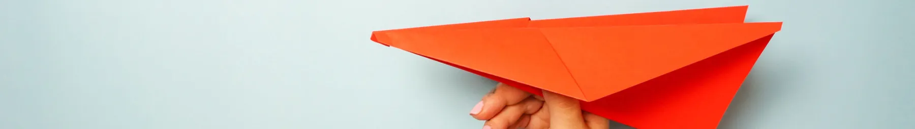 Red paper aeroplane being held