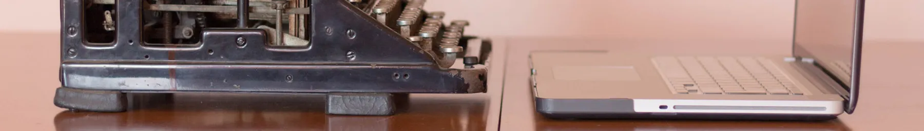 Typewriter and Laptop on a desk facing each other