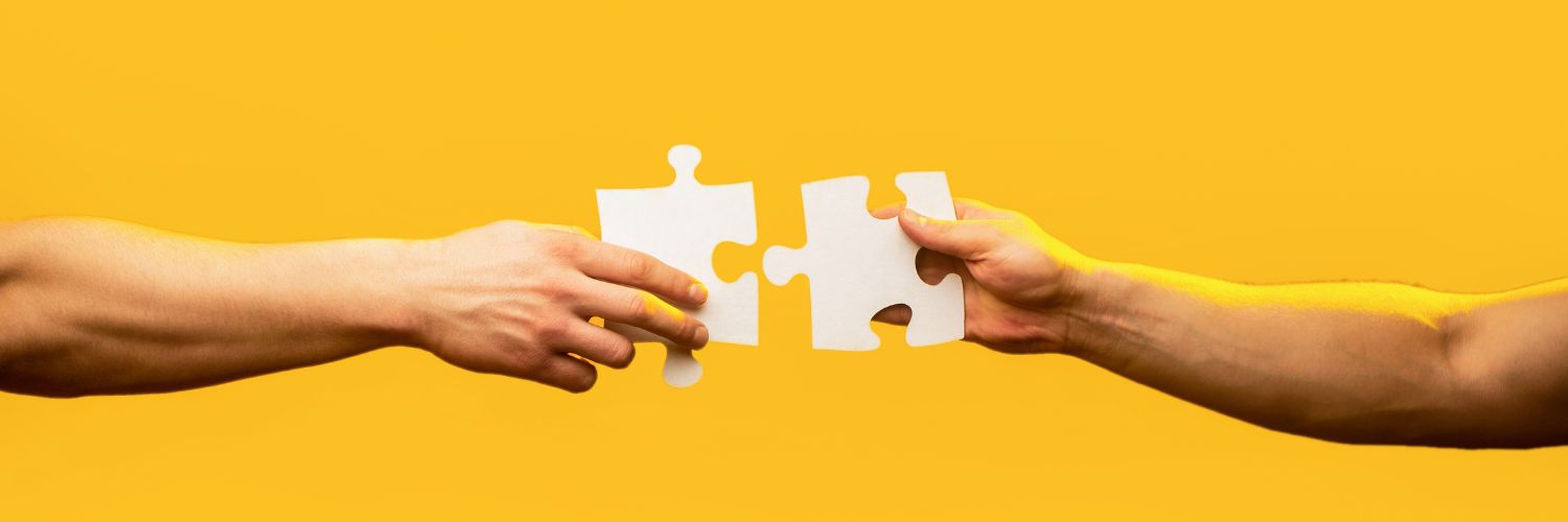 Two Arms With Jigsaw Puzzle Pieces Yellow Background