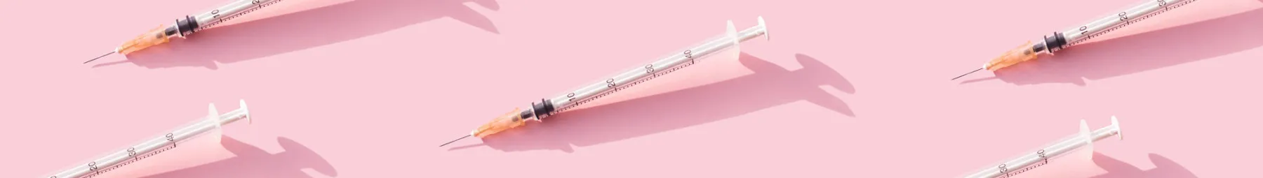 Multiple immunisation needles on a pink background (1)