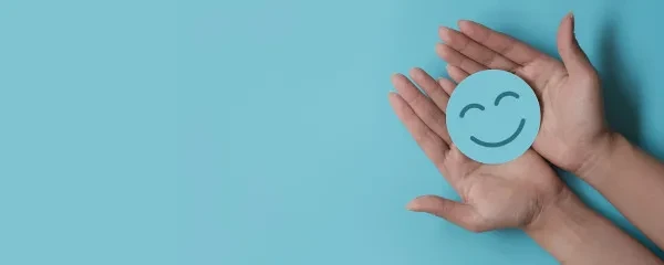 smiley face blue circle being held in hands