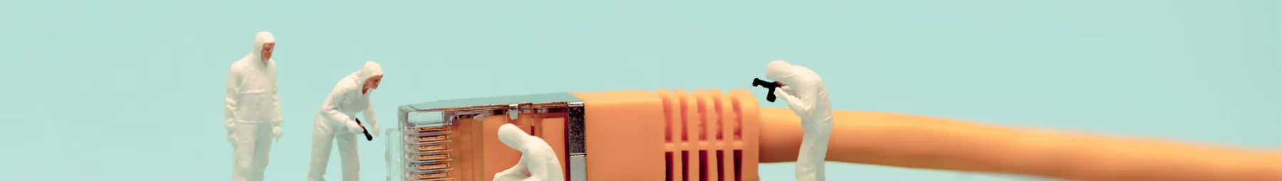 Men figures investigating computer cable