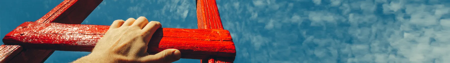 Red ladder with blue sky person's hand on ladder as climbing