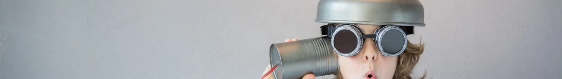 close up of child with tin can and string